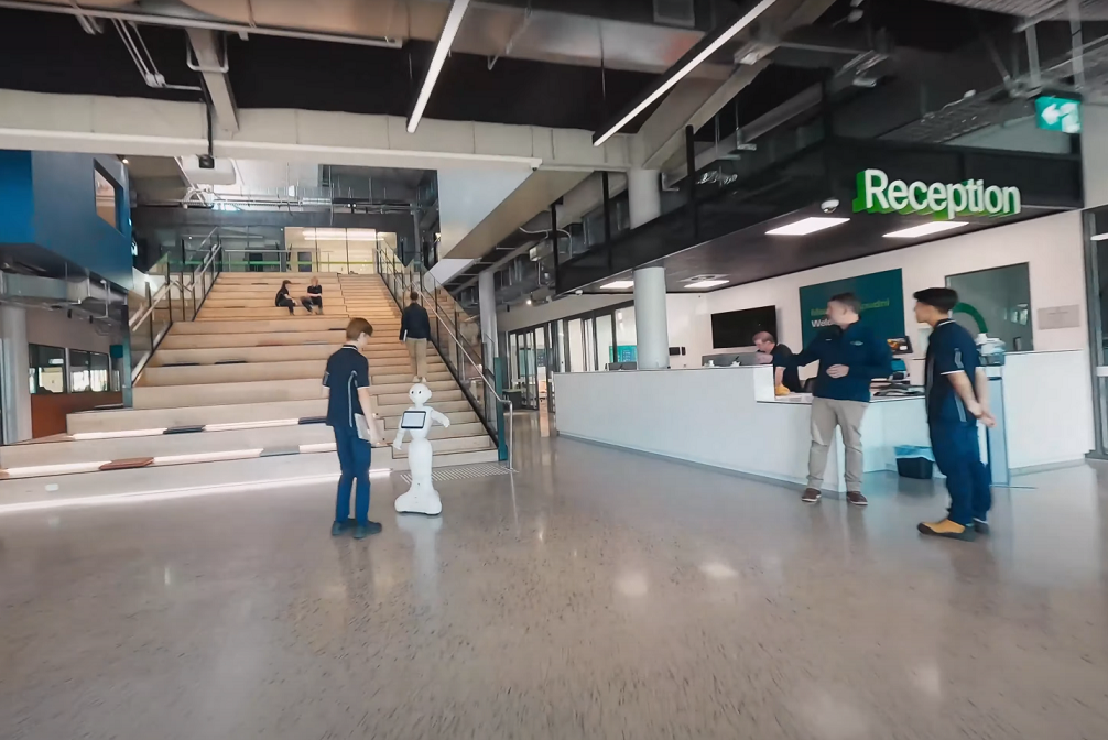 Foyer of Findon Technical College with students and AI robot.